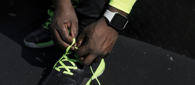 man's hands tying up his shoe lace